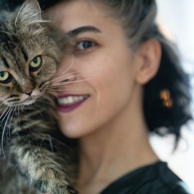 woman-carrying-brown-tabby-cat-3356488